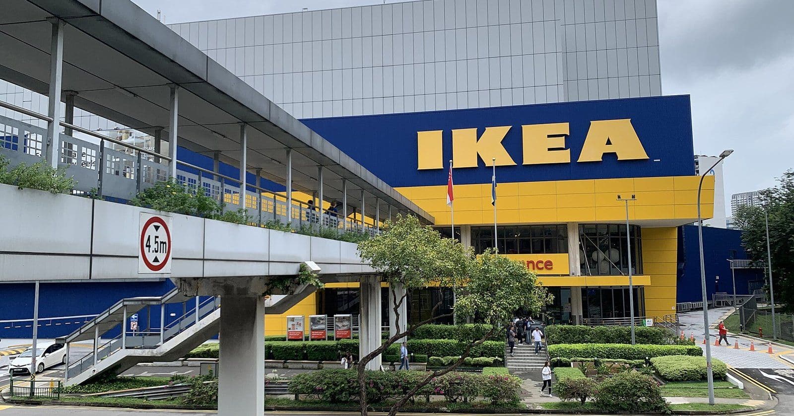 The blue and yellow front of the IKEA Alexandra store in Singapore, with a covered walkway and the road in front.