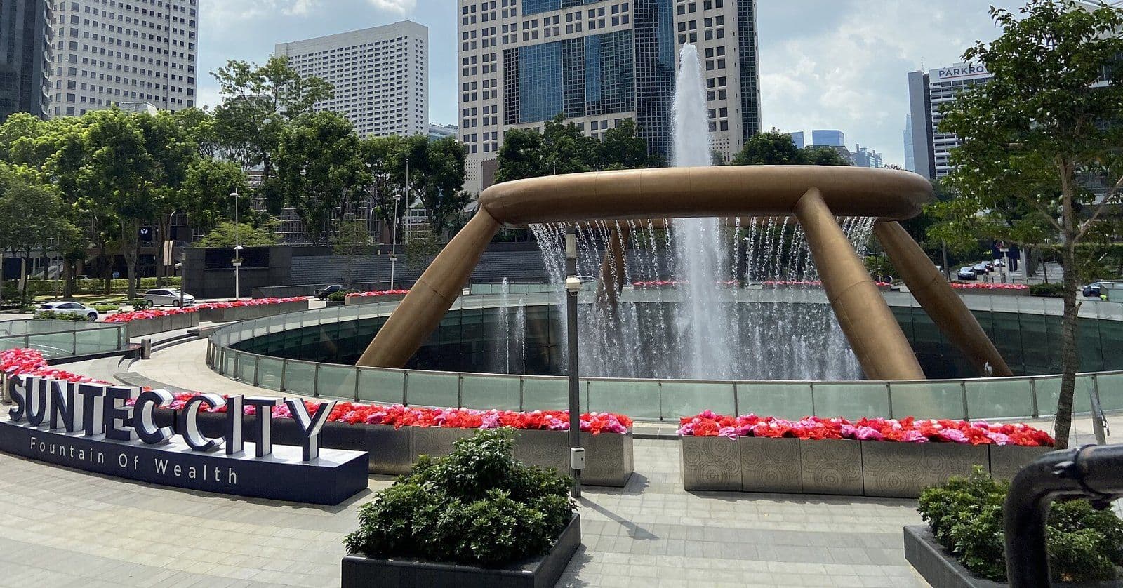 The Fountain of Wealth and the large Suntec City sign in Singapore, with the Suntec office towers behind.