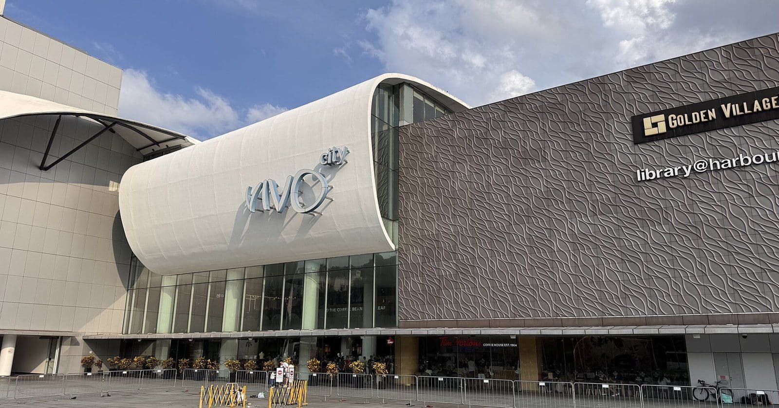The curved white front of the VivoCity mall at HarbourFront, Singapore, under a blue sky.
